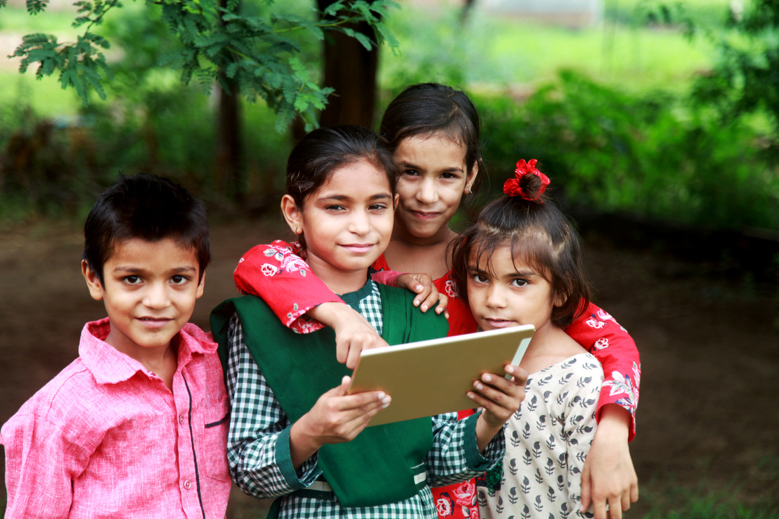Rural children holding digital tablet