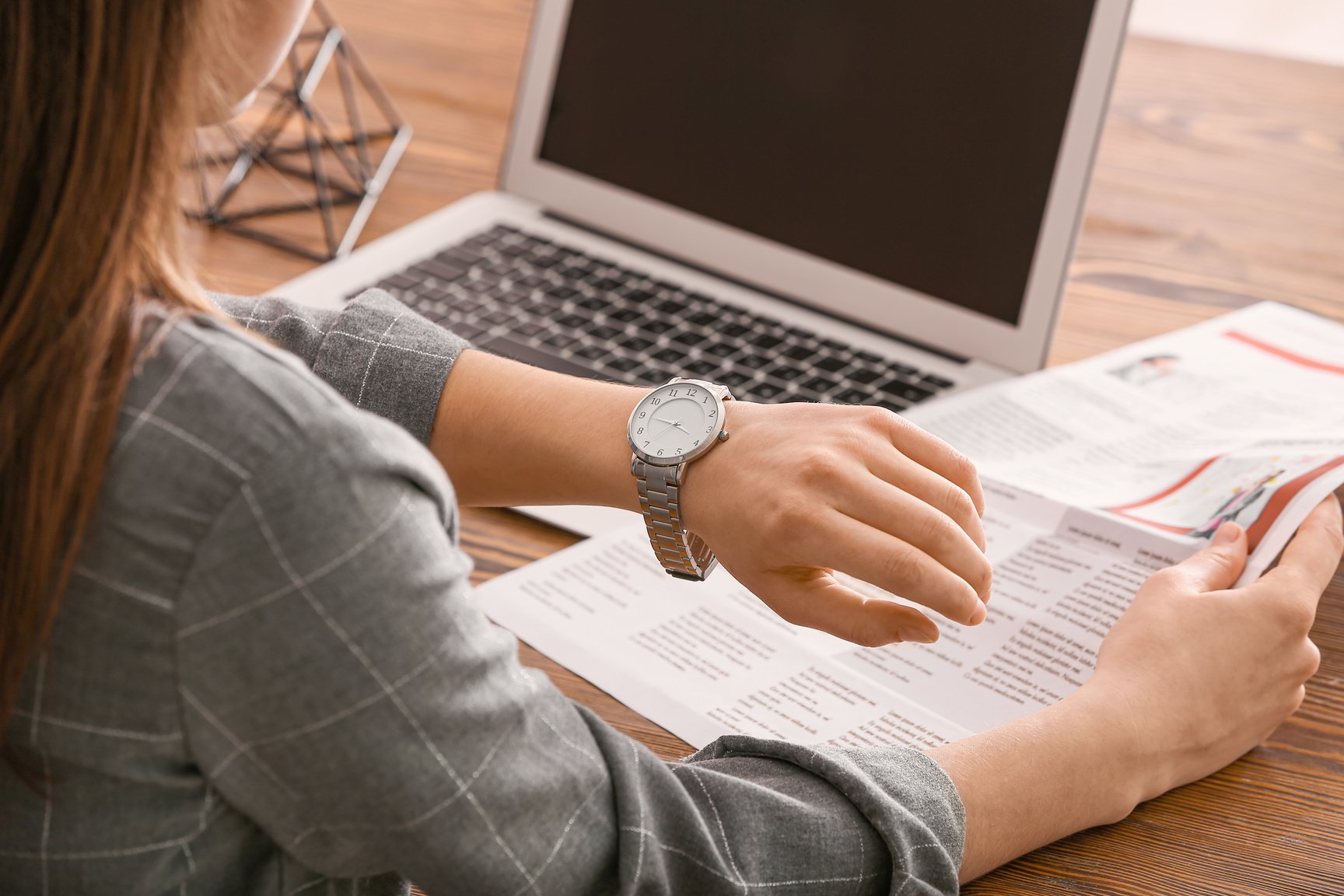 Woman Looking at Her Watch While Working