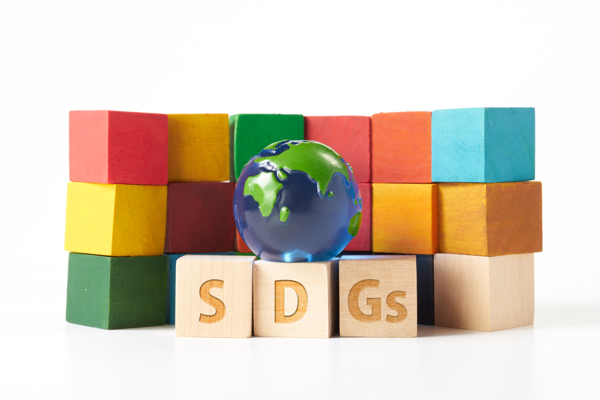 globe and a wooden cube stamped with the letters SDGs.