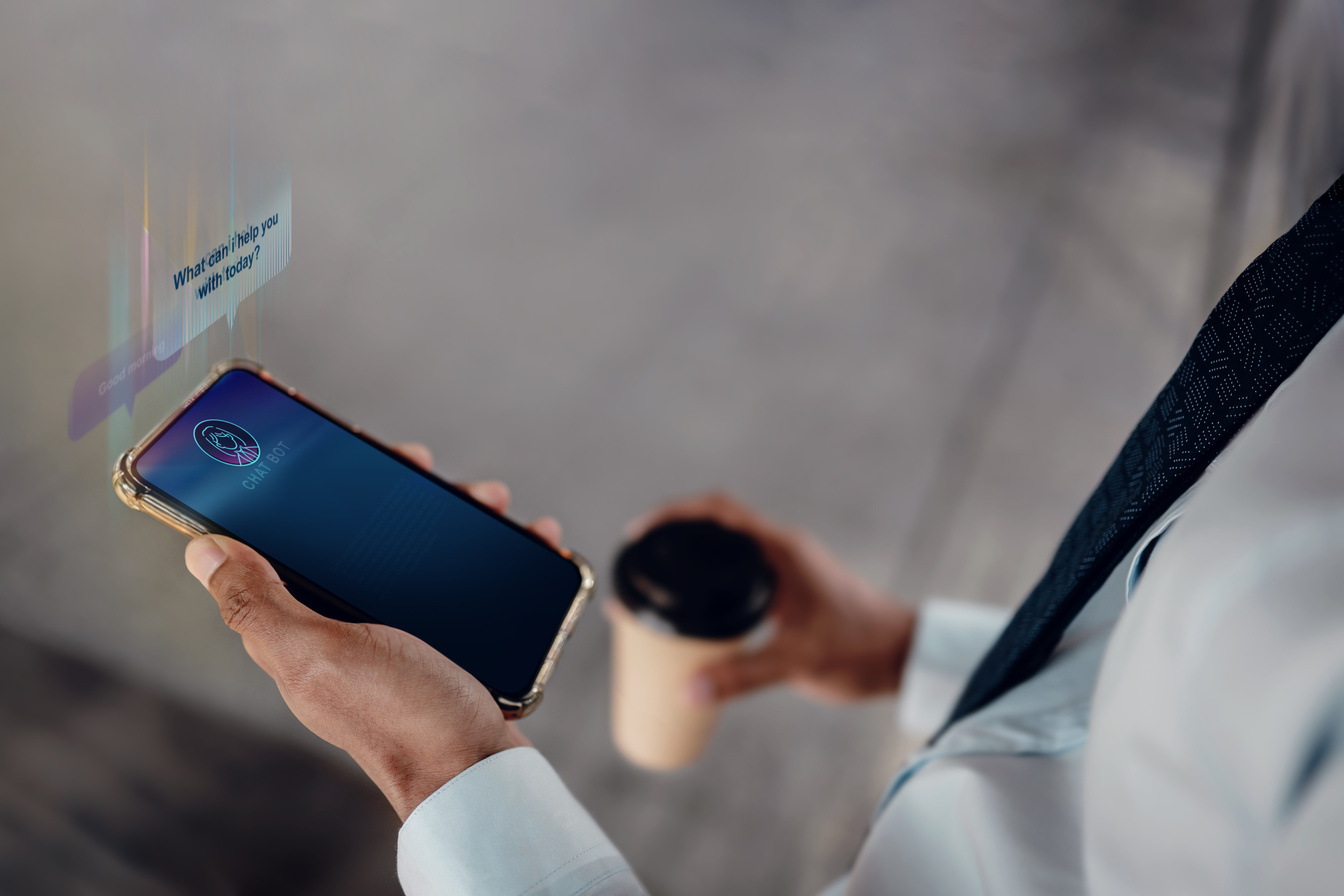 Chat Bot Technology Concept. Young Businessman Using Mobile Phone To Make Conversation with an Artificial Intelligence . Virtual Assistant for Customer Support Information