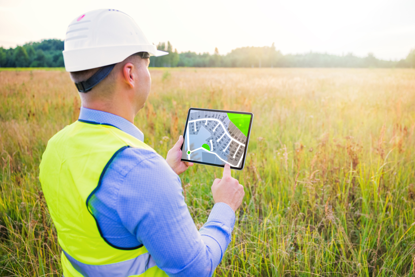 Architect Using Digital Tablet with Blueprints and Surveying a New Residential Housing Building Land Plot