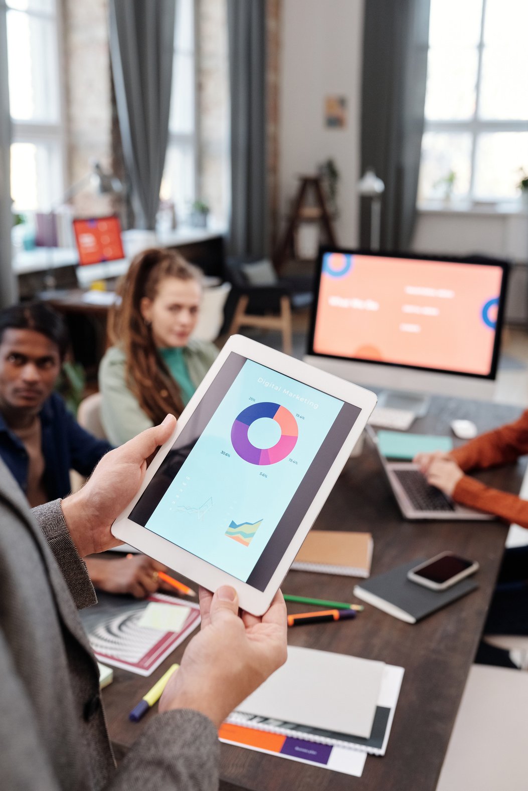 A Person Holding a Tablet with Digital Marketing Pie Chart on Screen 