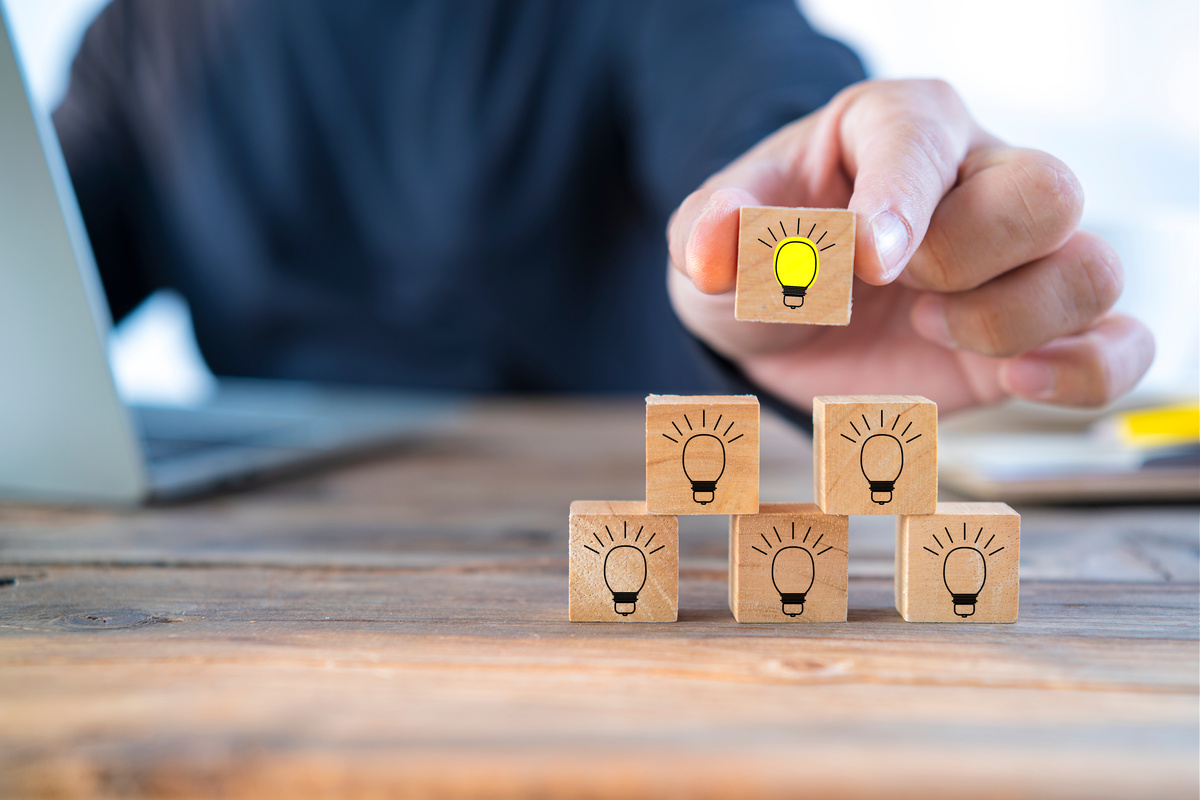 Close up businessman arranging a small wooden block with a light