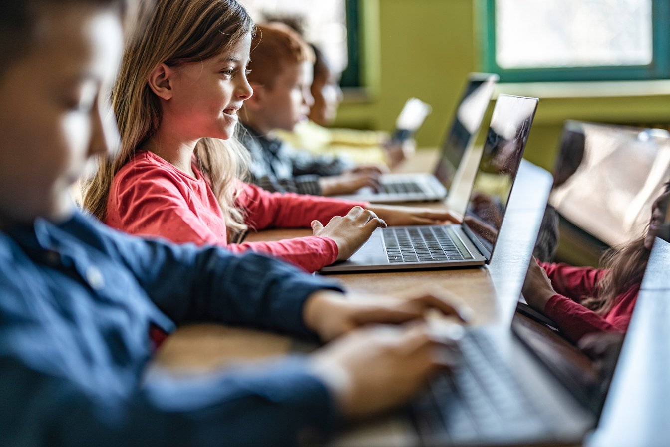 Digital native students e-learning over computers at school.