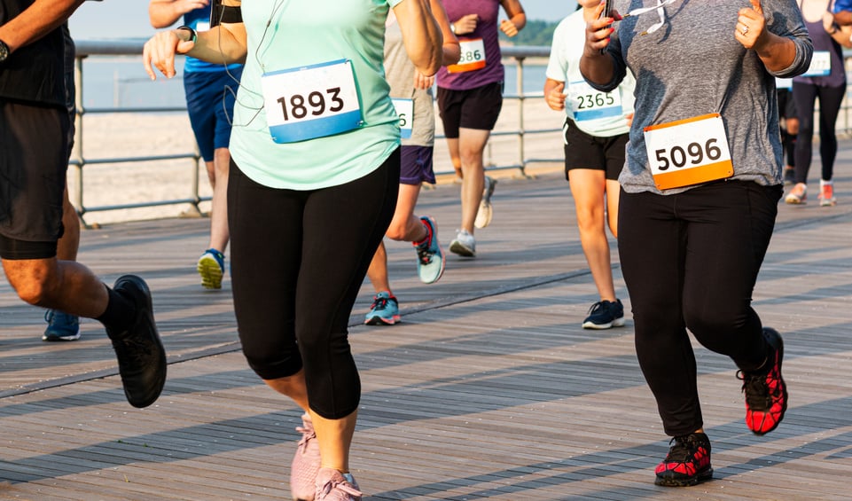 Runners running 10K rae on a boardwalk in the summer