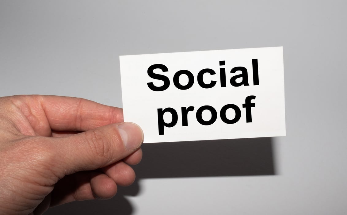 Message on the card SOCIAL PROOF in hands of businessman.
